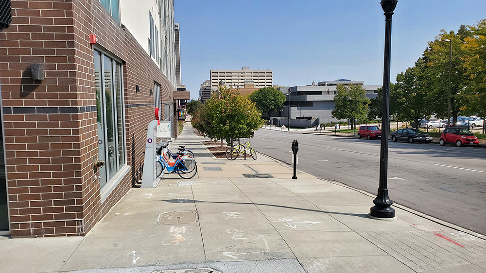 Sidewalk adjacent to the Even Hotel building with existing B-cycle station.